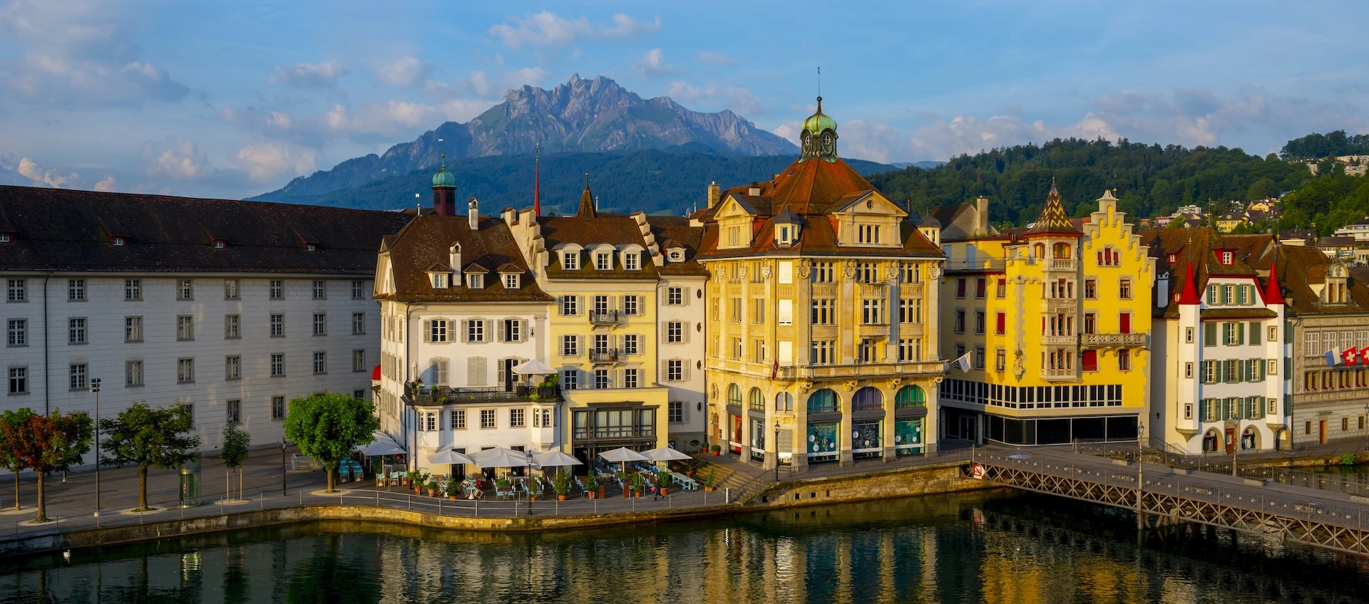 colorful-buildings-near-river-surrounded-by-mountains-lucerne-switzerland